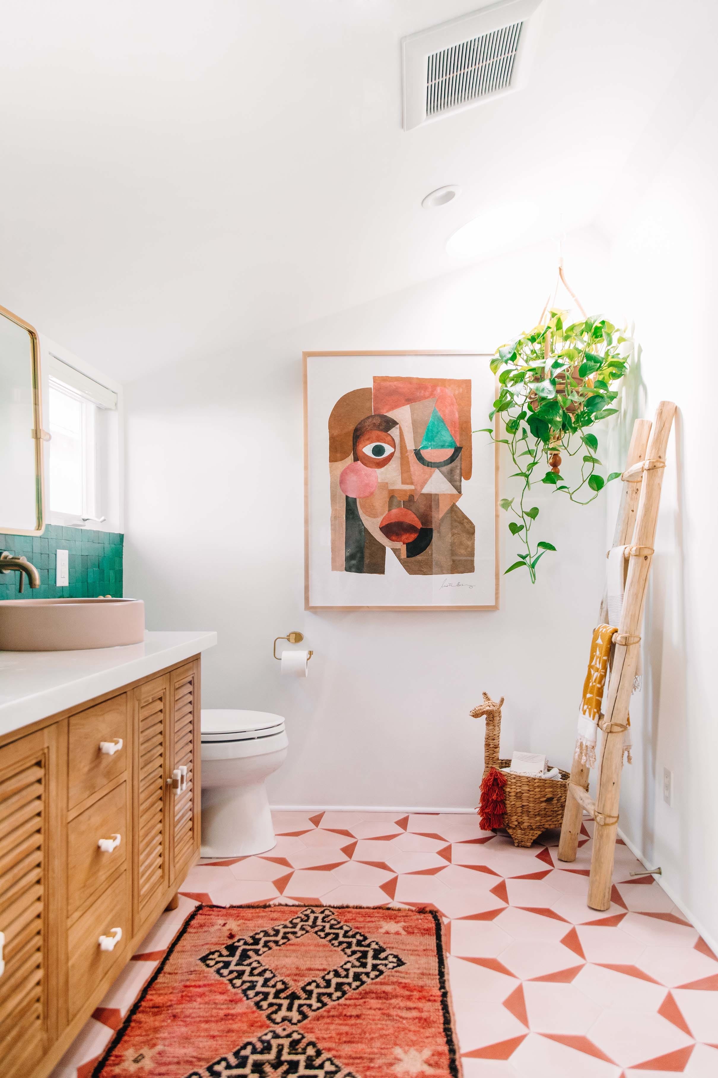pink and green bathroom with Sun Tunnel and plant