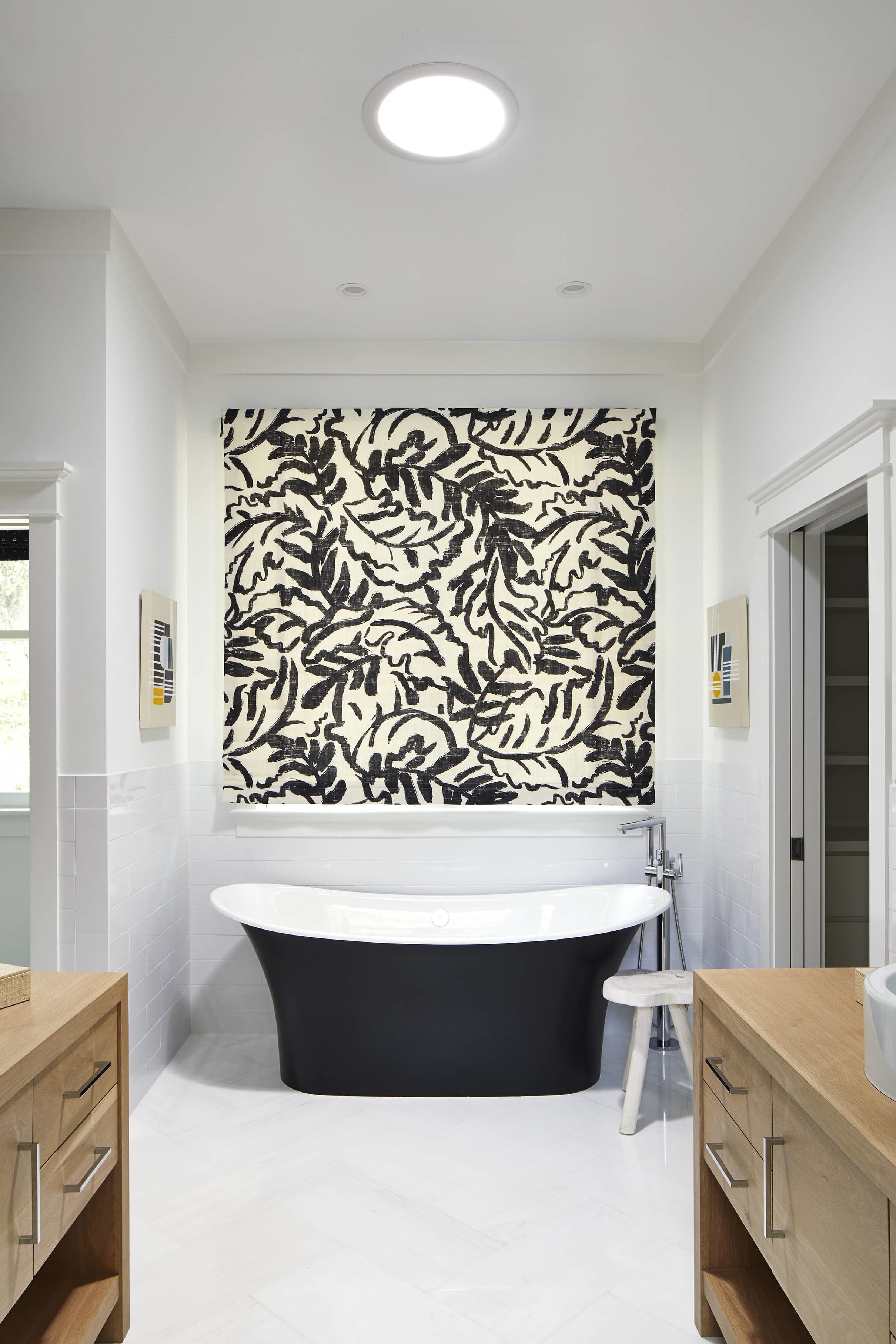 bathroom with black and white windowshade and a Sun Tunnel above black bathtub