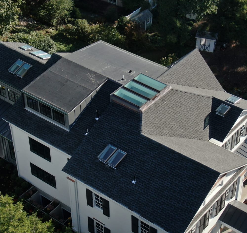 A bird's eye view of a house with many skylights installed on the roof.