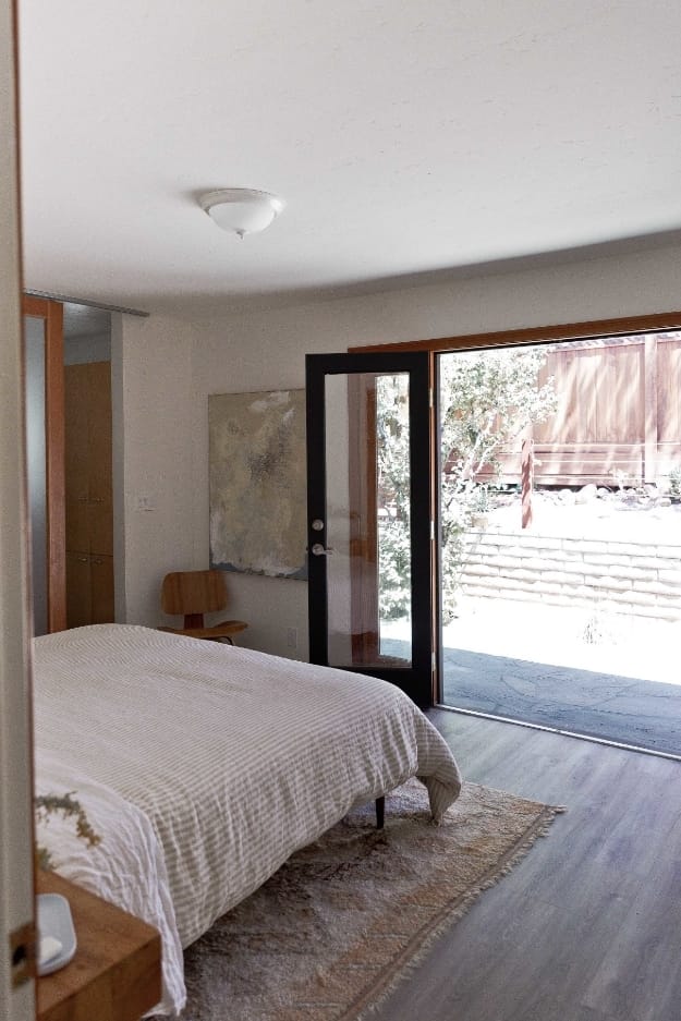 Bedroom natural wood doorframe neutral color bedding