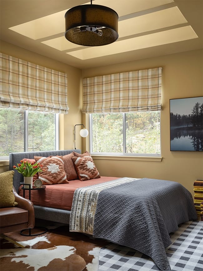 Bedroom painted yellow with three skylights and gray accents