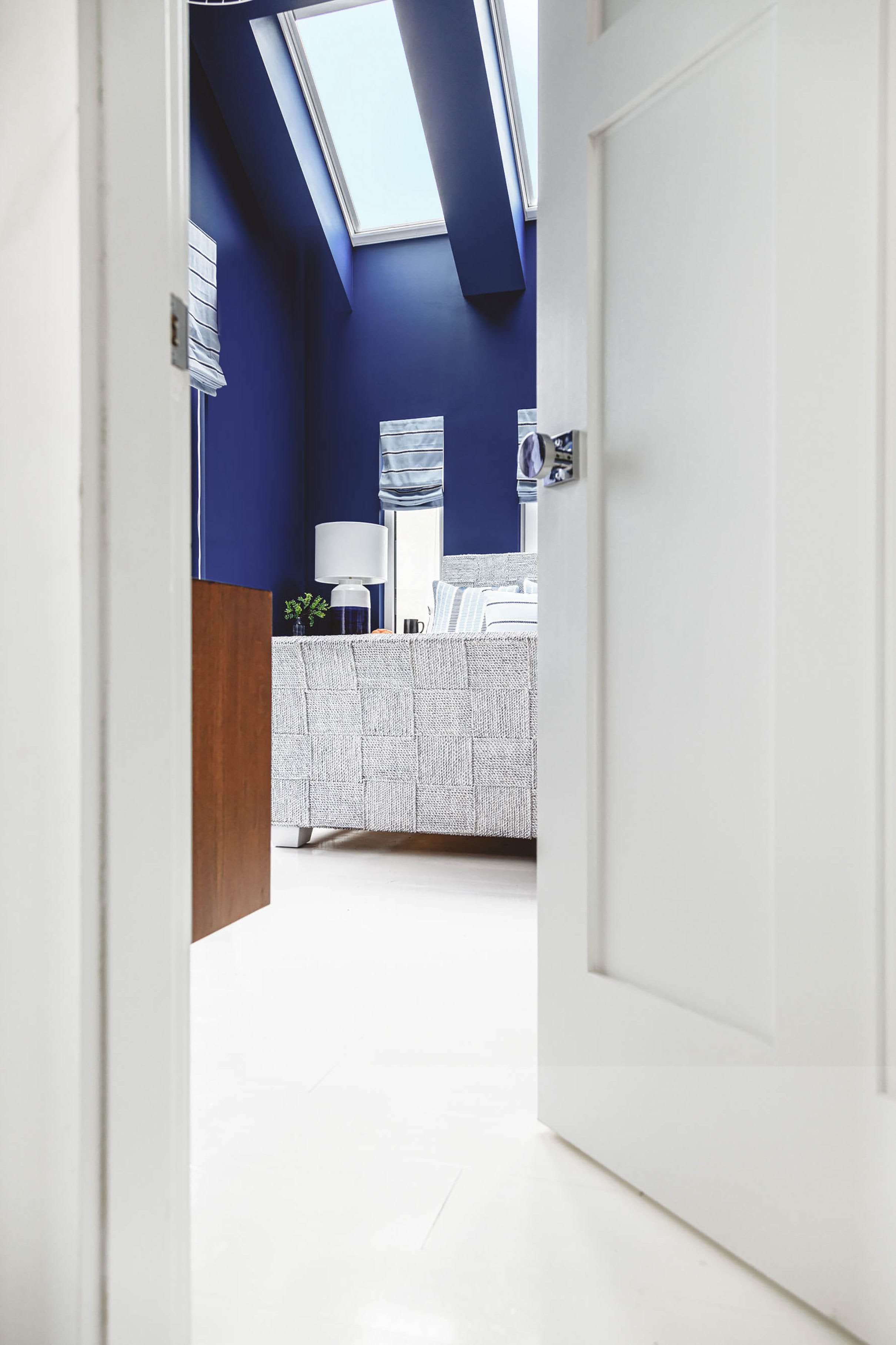 blue bedroom with two skylights view through a doorway