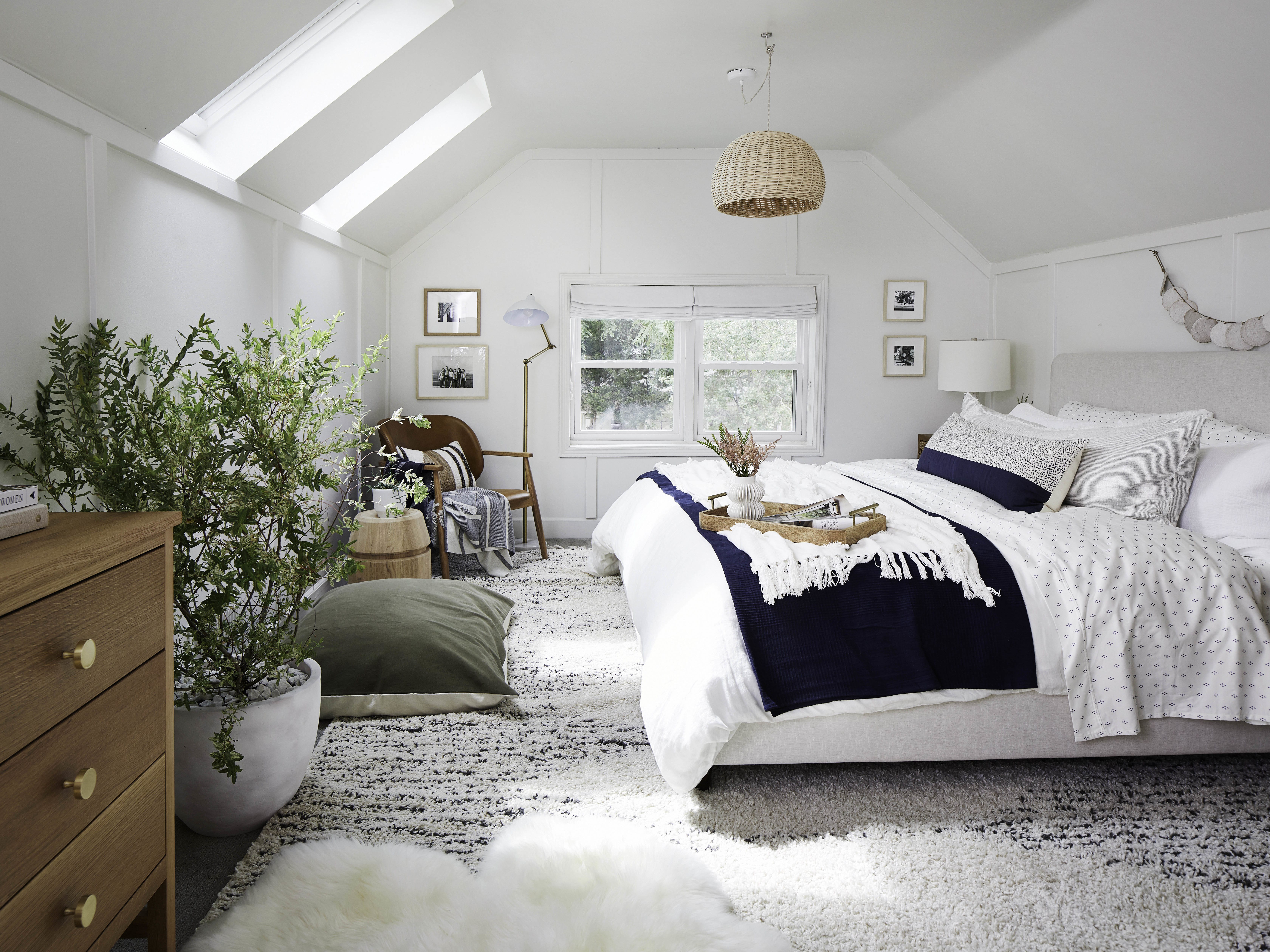 Attic bedroom with two skylights and a blue and white color scheme