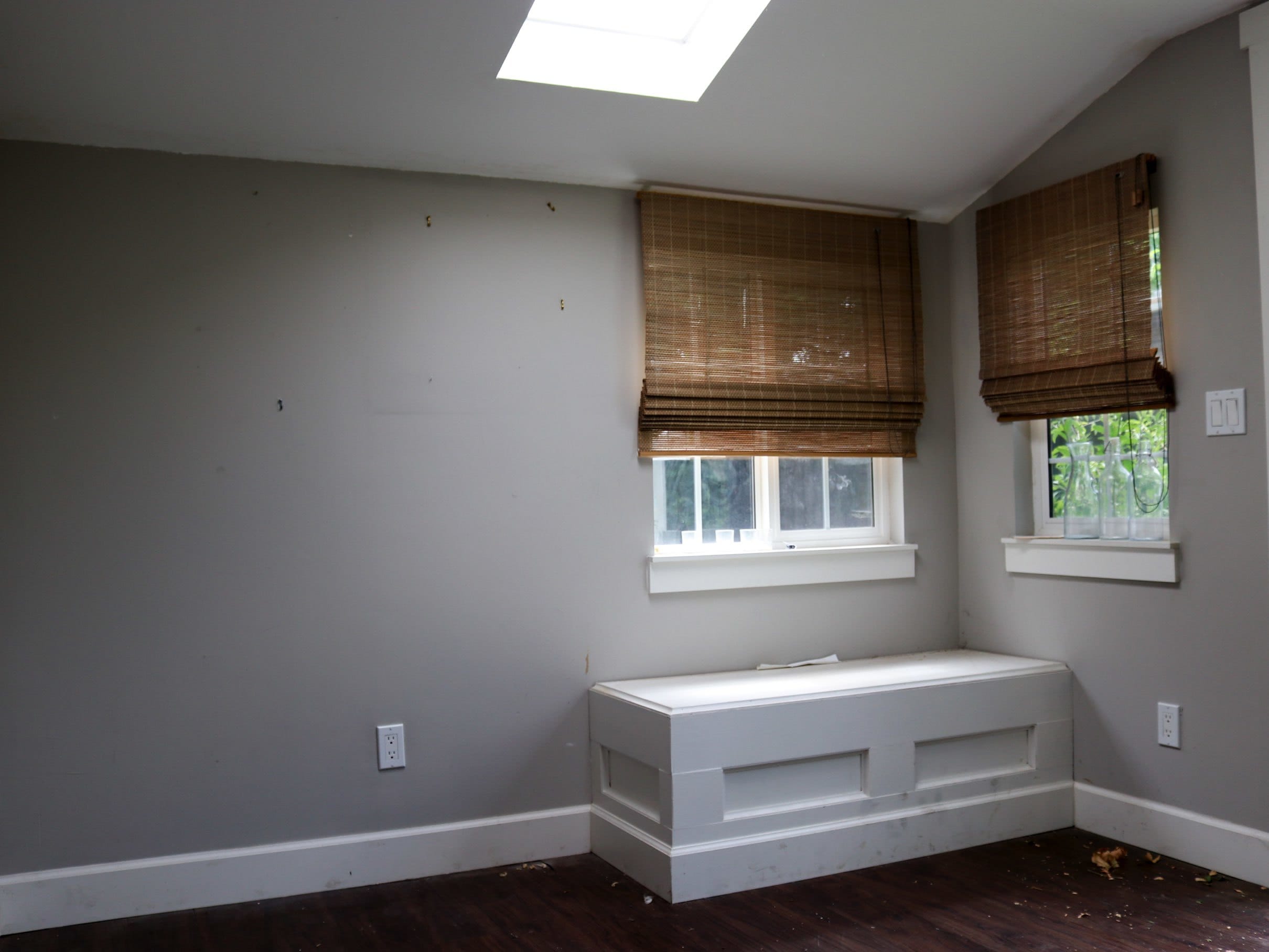 empty and dark room with two windows with natural shades