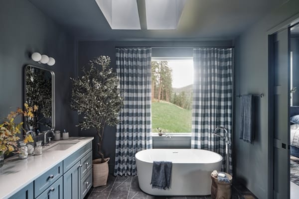 Gray bathroom with tub and skylights