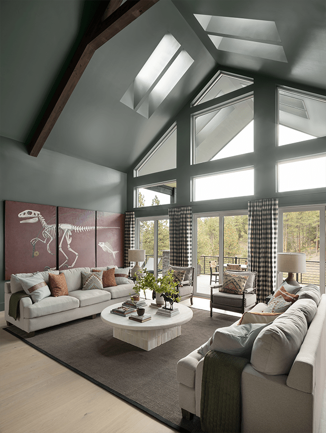 Green living room with four skylights dinosaur art and white couches
