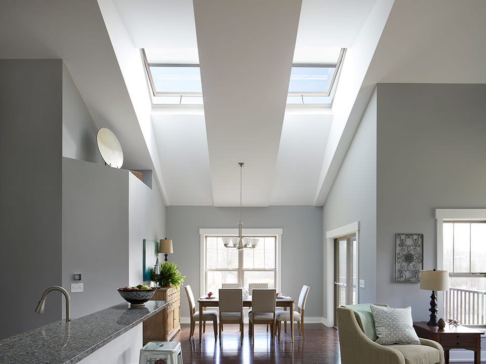 Open floor plan room with two skylights gray and white