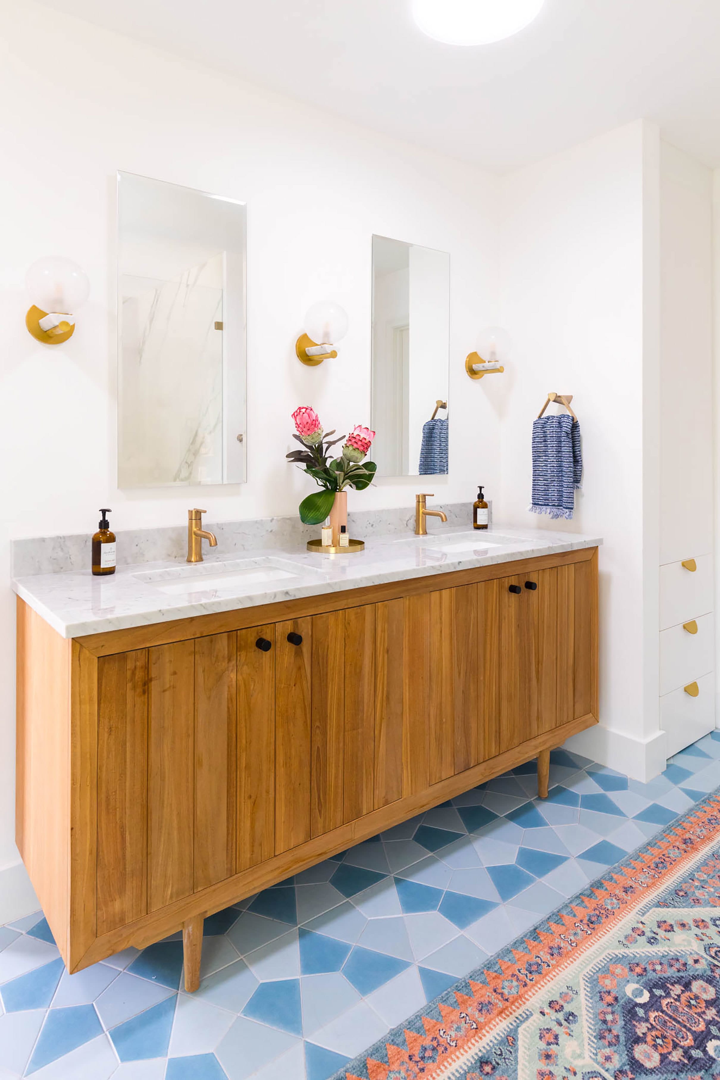 A blue and white bathroom with pink accents and Sun Tunnel skylights
