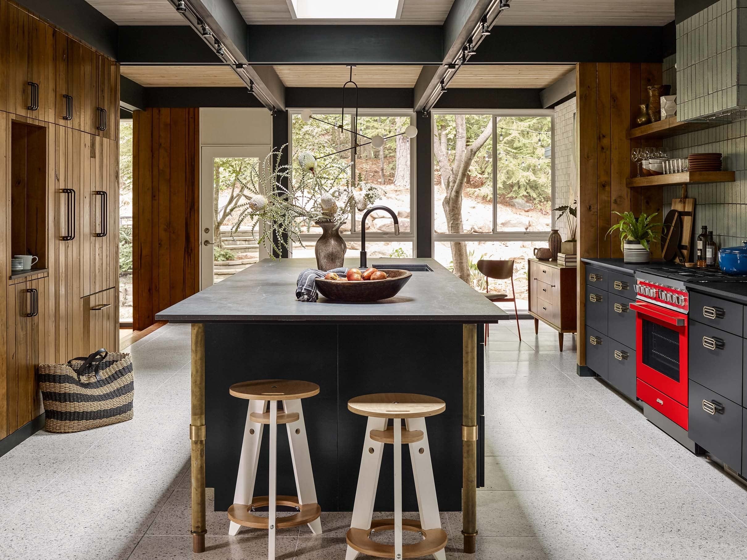 Modern kitchen with skylight over island red oven natural wood cabinets
