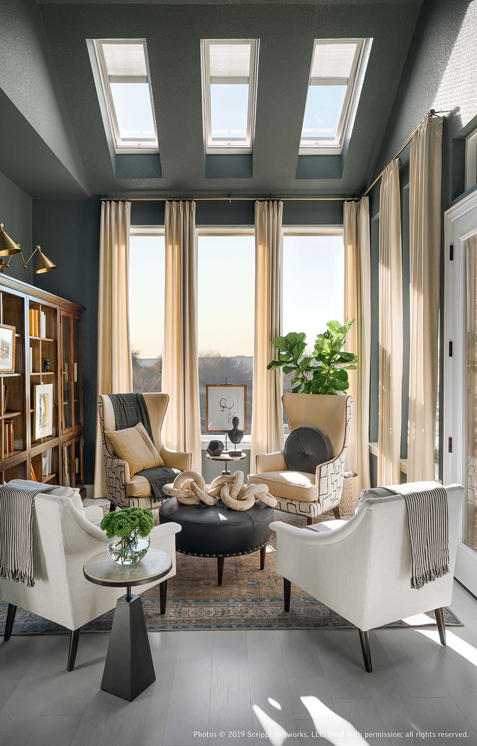 Sitting room with dark grey walls, three skylights and cream draperies