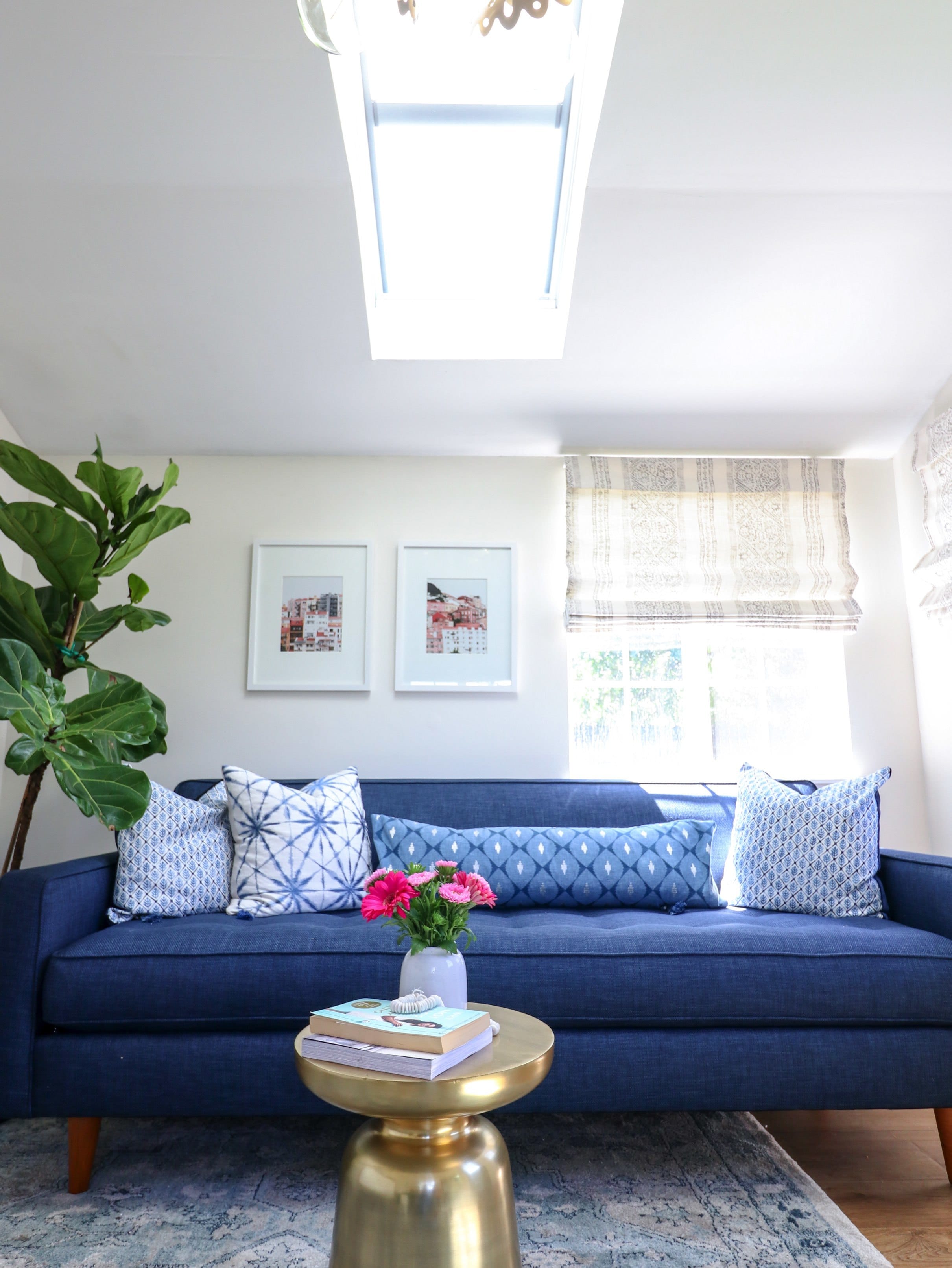 skylight brightens small room with a blue sofa