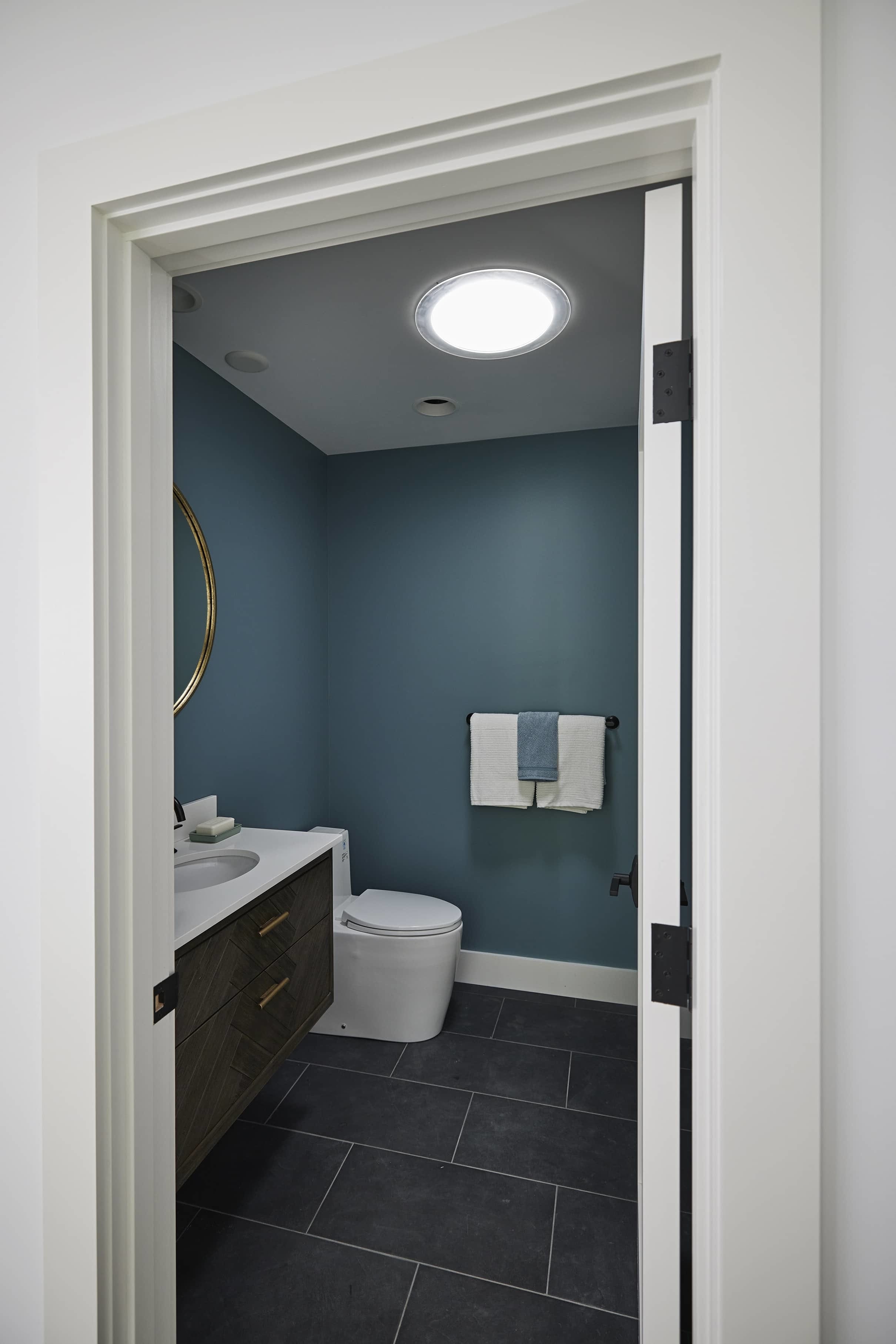 Small bathroom blue walls sun tunnel skylight
