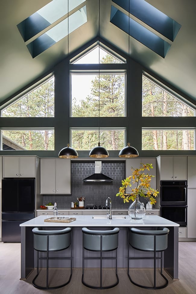 A kitchen with four skylights green gray walls and white cabinets and countertops