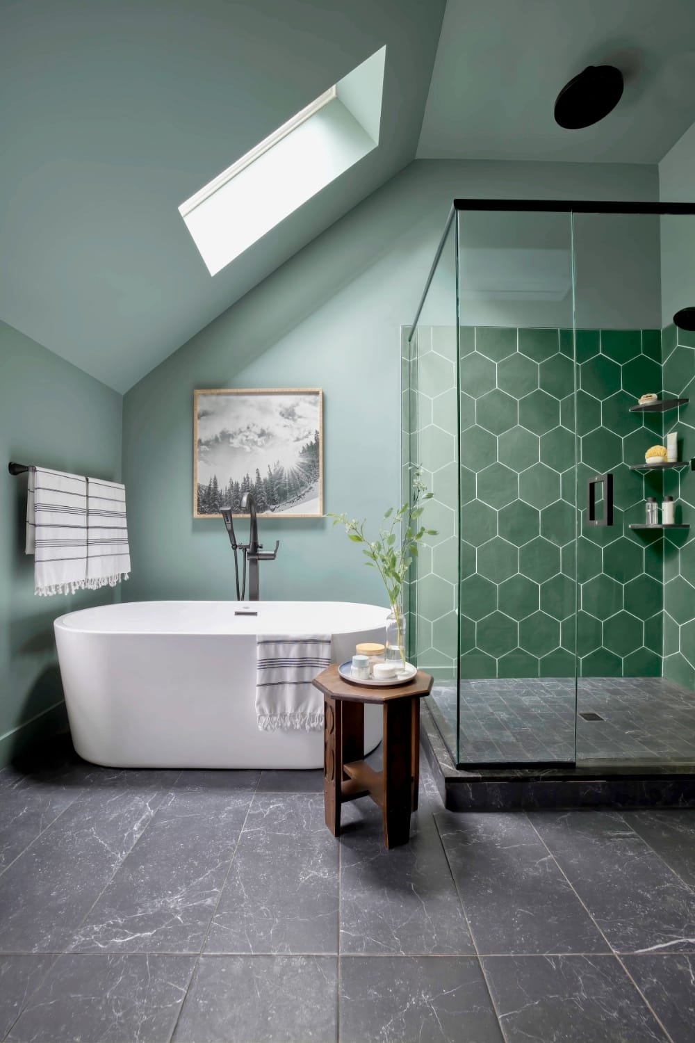bathroom with green painted walls and matching hexagonal shower tile with a skylight over the bathtub