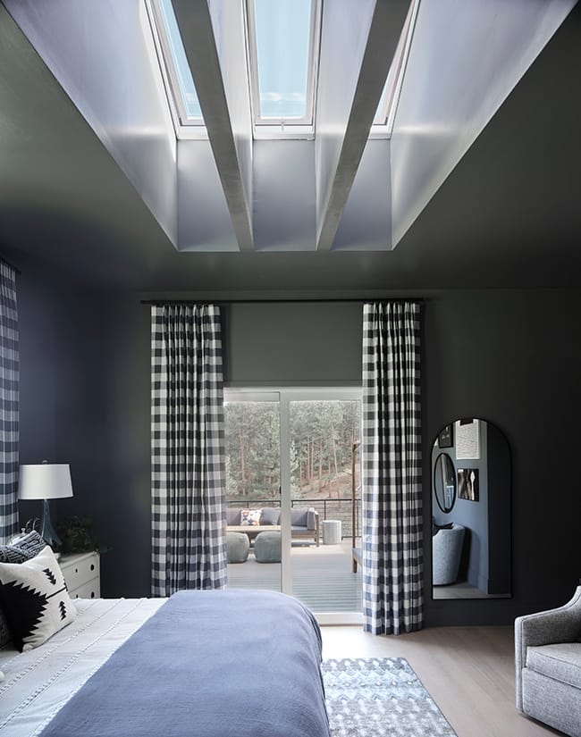 Bedroom with dark gray walls three skylights and checkered draperies