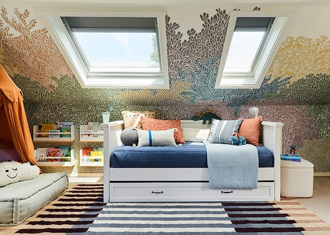 Childrens room with skylights and colorful tree themed wallpaper