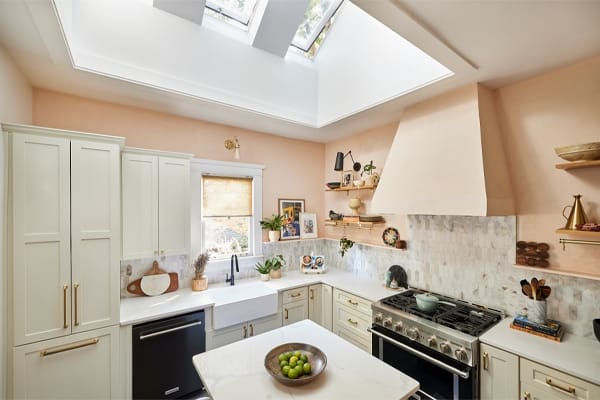 Kitchen with three skylights peach colored walls and white cabinets TMB