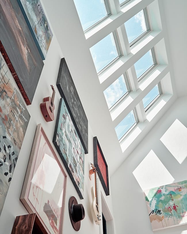 Looking up at a gallery wall to skylights that fill the space with natural light