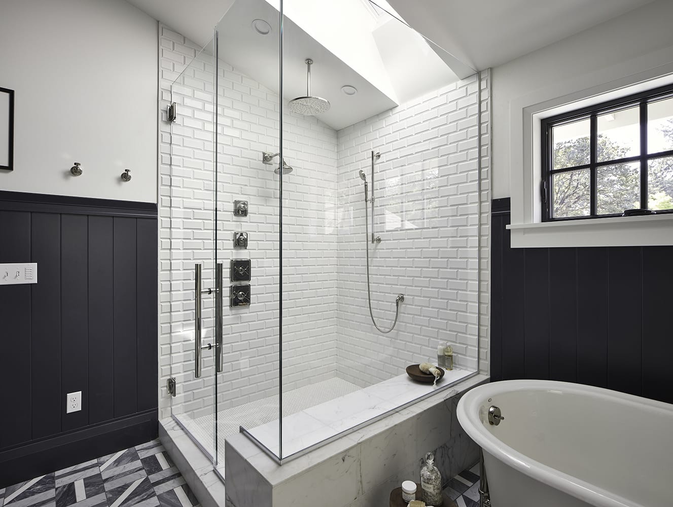 Wide angle of a glass shower with white tile and a skylight on the ceiling above