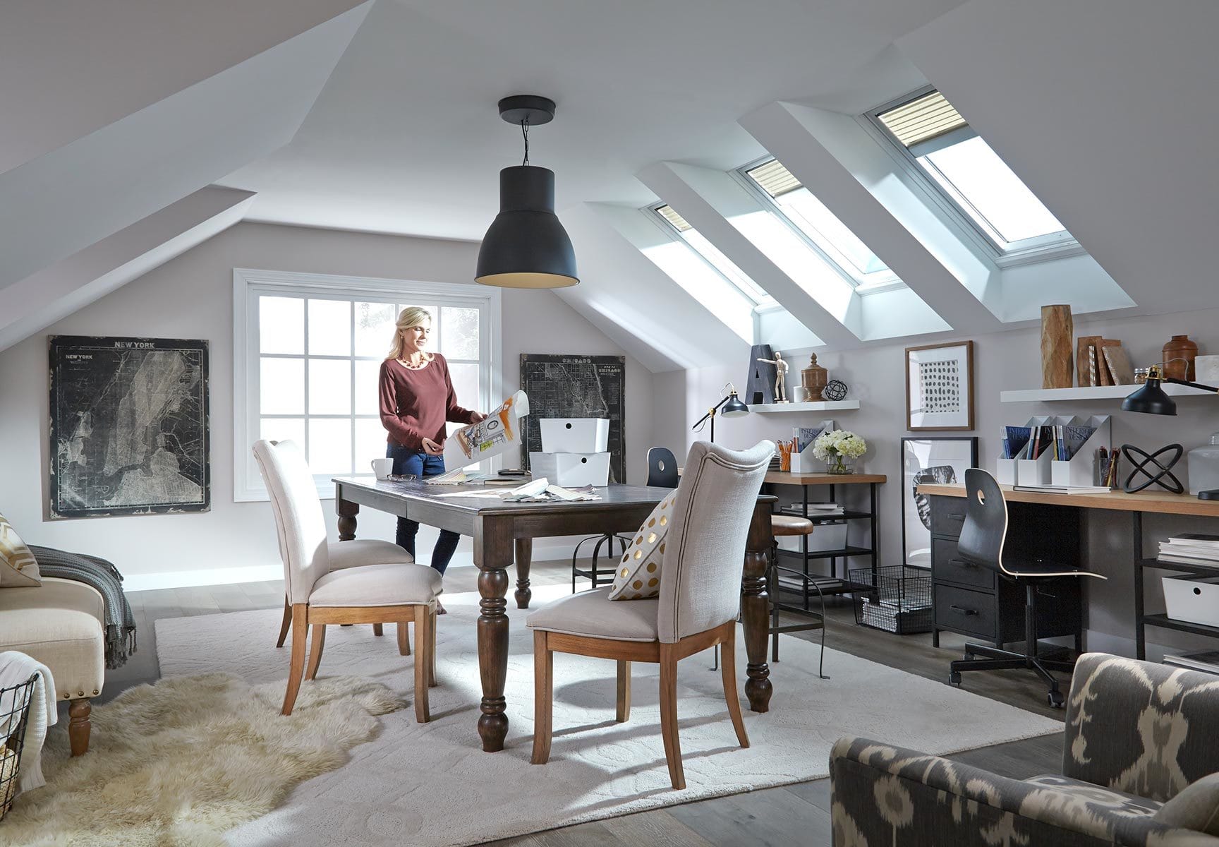 Woman works at a table in an upstairs bonus room with three skylights
