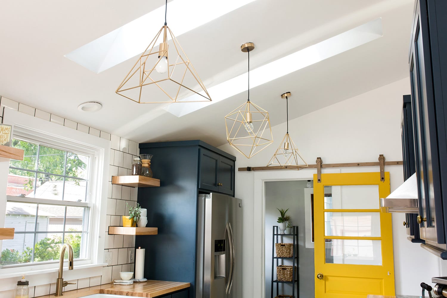 Close up of two skylights in a bright white kitchen with a yellow door